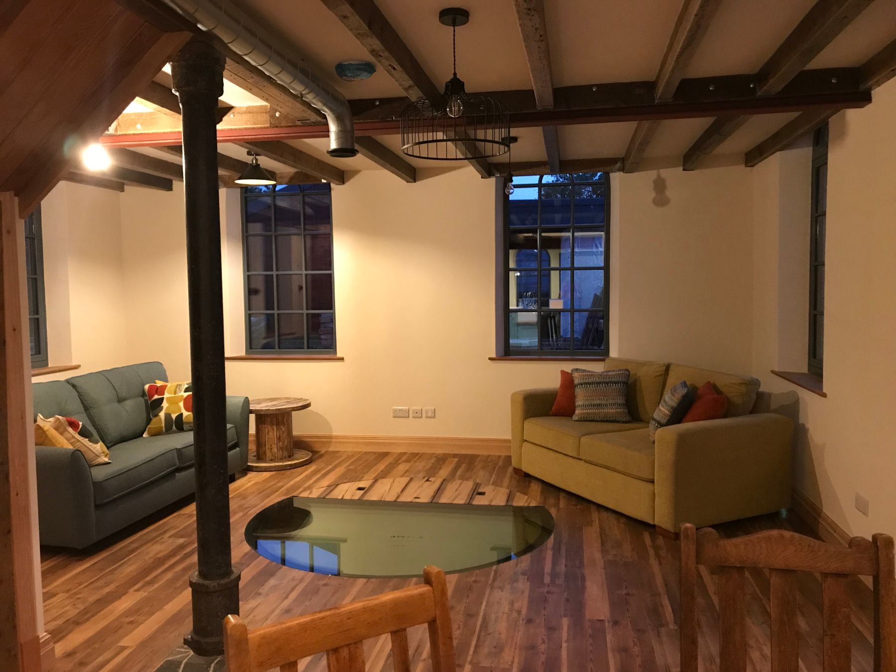 Pumphouse living room with reclaimed cast iron column supporting first floor